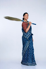Young asian woman of indian origin with a sweeping broom