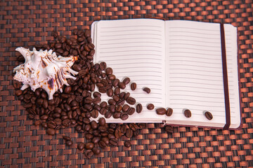 Notepad with scattered coffee beans and seashell