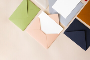 Close-up colorful mail envelopes on beige background flat lay with copy space, top view. Mailing...