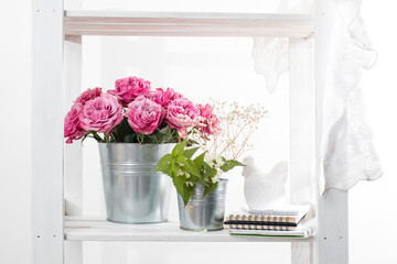 Bouquet of red roses in a tin bucket on a white wall background. Copy space