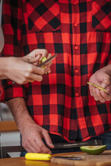 cropped view of girl cutting fresh avocado near boyfriend