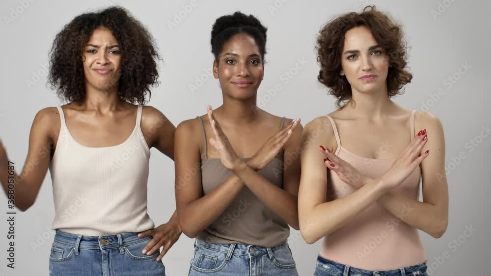 Wall mural three serious multi-ethnic women are showing no gesture while gesturing with crossed hands isolated 