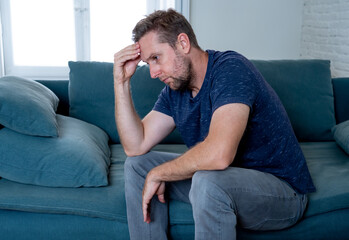 Young man suffering from depression feeling lonely, distressed and hopeless isolated at home