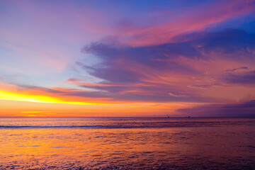 Naklejka na ściany i meble Colourful sunset, red-orange clouds on sea horizon background.