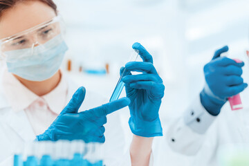 close up. female scientist looking at the liquid in the test tube.