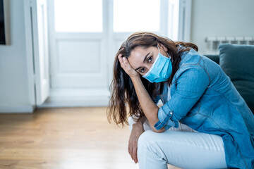 Lonely woman suffering from depression at home during coronavirus lockdown and social distancing