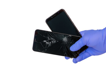 gloved hand holds a broken smartphone with a cracked mobile phone screen and a new mobile phone...
