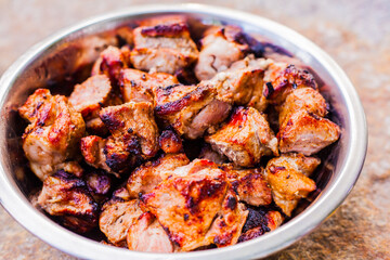 Shish kebab in an iron plate on the background of a stone.