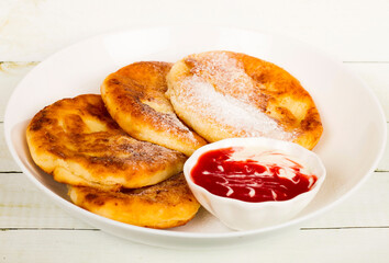 Pancakes on a white plate with mashed strawberies