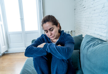 Young sad woman suffering from depression feeling lonely and hopeless isolated at home