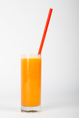 Orange juice in glass with a red straw