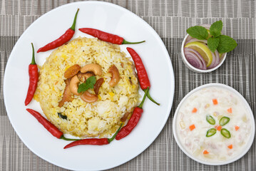 Spicy and delicious chicken biryani in traditional clay pot. Malabar biryani or Hydrabadi chicken biryani, Dum Biriyani, Chicken pulao basmati rice, herbs, raitha for Ramadan Kareem, Eid