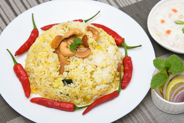 Spicy and delicious chicken biryani in traditional clay pot. Malabar biryani or Hydrabadi chicken biryani, Dum Biriyani, Chicken pulao basmati rice, herbs, raitha for Ramadan Kareem, Eid