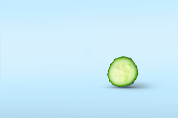 One big slice of fresh cucumber close-up vertically with shadow on a blue background. Concept of...