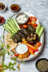 Middle Eastern meze platter with vegetables, crowd and tzatziki sauce