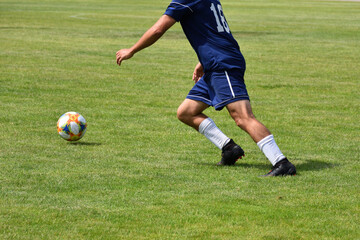 Football, soccer player running with the ball, closeup view of legs