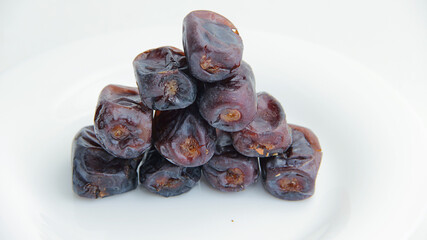 Proper nutrition dried fruits and dates instead of sweet. Dates are stacked on a white background.
