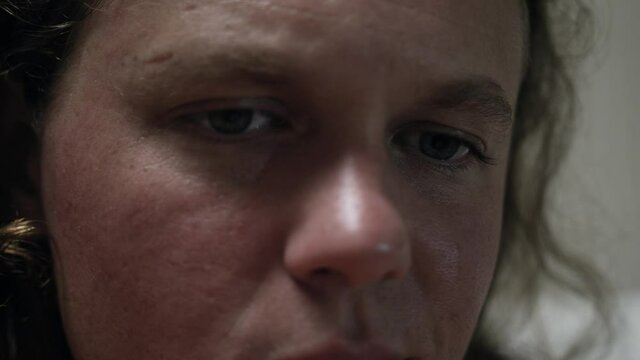 Closeup of an emotional man's eyes in prison as he reads a bible