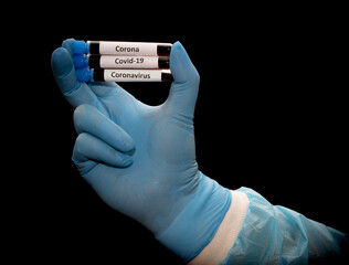 Hand in glove holding a test tubes with labels of corona virus, covid-19, isolated on a black background. Samples with testing blood.