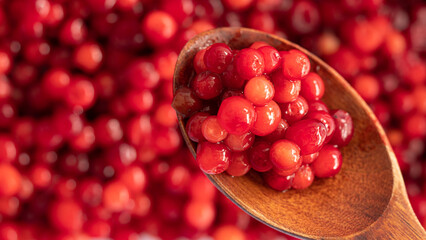 Cranberry placed in a wooden spoon and placed on a wooden floor,  Red sour fruit  There are many health benefits.