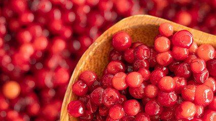 Cranberry placed in a wooden spoon and placed on a wooden floor,  Red sour fruit  There are many health benefits.