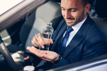 Close up of kind bearded man that looking at pill