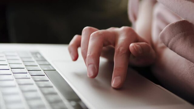 The woman's hand uses the trackpad of the modern laptop sculpting of the computer with special multi-touch gestures.