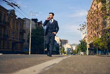 Kind young brunette man walking along the street