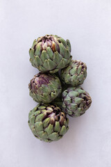Fototapeta premium Topview image of artichokes on a light gray background.
