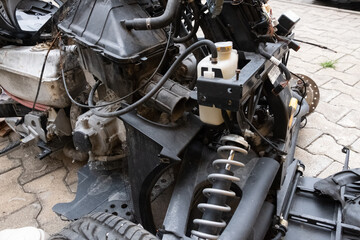 Vehicle, tricycle, after an accident. A burned motorcycle near the workshop. Mechanism metal covered in ashes. Various motorcycle mechanisms are visible. Gears, springs, tanks, skeleton, traction.
