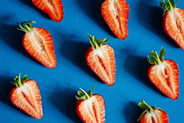 Fresh ripe strawberries on a blue background.  Berries, Fruit pattern, Flat lay, top view, copy space. Summer concept. Colorful ripe strawberry pattern.