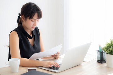 Beautiful young asian woman work and type with laptop computer at office, businesswoman looking graph diagram analysis statistic data of finance, girl using notebook, profit growth, business concept.