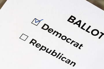 Obraz premium Checklist concept. Closeup of ballot paper with words Democrat and Republican and a pen on it. A checkmark for Democrat in the checkbox.