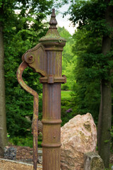 Fototapeta na wymiar hand water pump Retro style. Manual vintage construction in green park