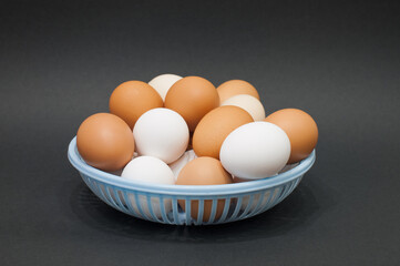 blue basket with a lot of village chicken eggs on a black background. natural protein. ingredients for sports nutrition.