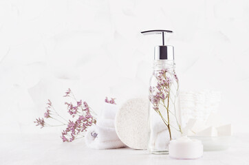Elegant white cosmetic products and accessories for bathing and spa in soft light white interior with copy space.