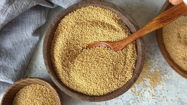 Raw Amaranth seeds in a bowl with a spoon close up