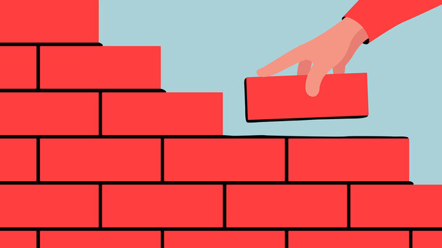 Vector illustration of unfinished brick wall. Bright illustration of a red brick wall construction with a hand putting a brick along with the rest.