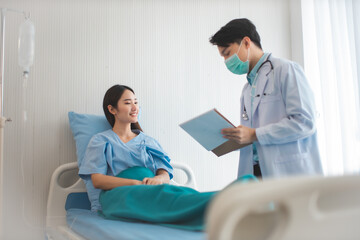 Obraz premium Medicine and health care concept. Asian doctor is taking care patient woman in hospital.doctor or nurse wear protection mask checking and takecare infection people from covid-19 .