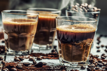 Coffee in glass cups mixed with cream and sprinkled coffee beans