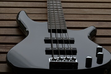 Ein schwarzer E Bass Gitarren Korpus von unten fotografiert. Man sieht nur die obere Seite des Basses mit den Knöpfen und der Seitenhalter mit den Seiten.