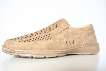 Men's beige leather shoes, models moccasins. Photographed close-up on a light background.