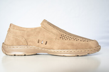 Men's beige leather shoes, models moccasins. Photographed close-up on a light background.