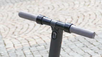 Electric scooter parked on cobblestones in the city center.