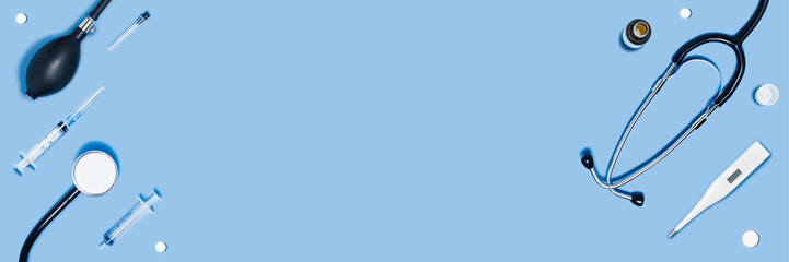 Medical different accessories on blue web banner: stethoscope, thermometer, tablets, notepad.