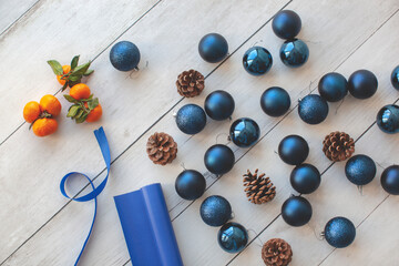 Naklejka na ściany i meble Christmas balls, layout for the New Year and Christmas. Tangerines, pine cones and brown paper. Flat lay, top view, copy space. 
