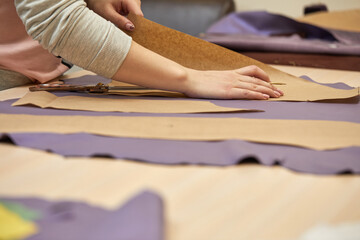 Tailor woman is working at table in atelier