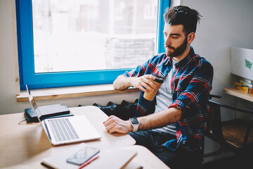 Portrait of cheerful male software developer working with netbook