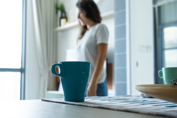Morning mug of coffee on the table on the background of a girl.
