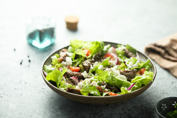 Green salad with beef steak and fresh cheese